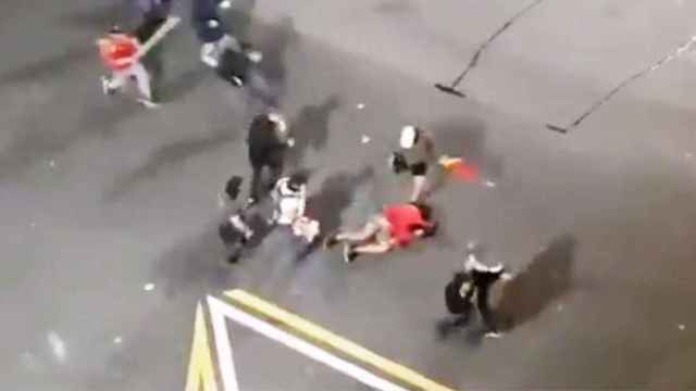 Un manifestante 'indepe' en el suelo mientras los ultras lo apalean / TWITTER