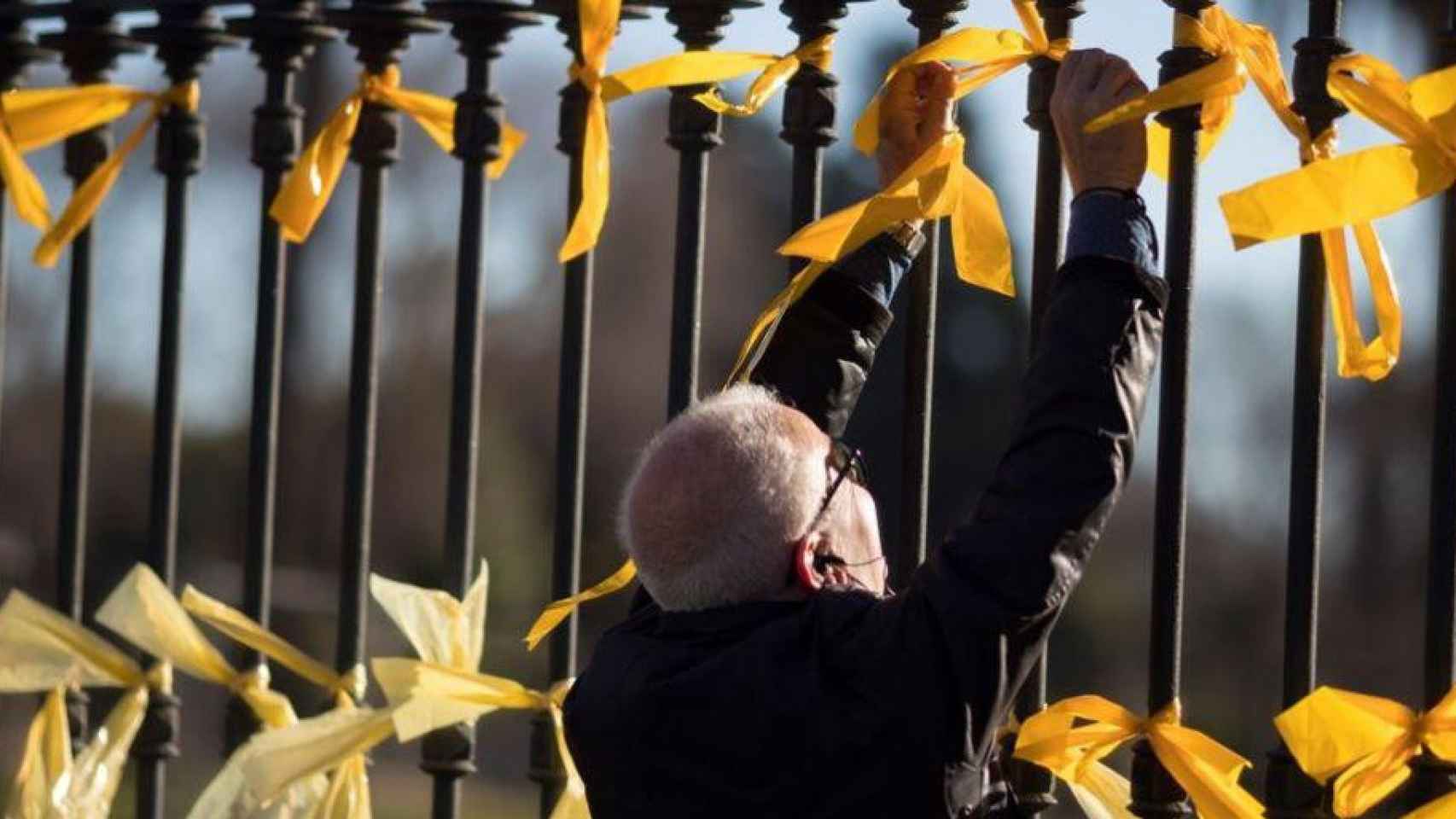 Un ciudadano retirando lazos amarillos / EFE