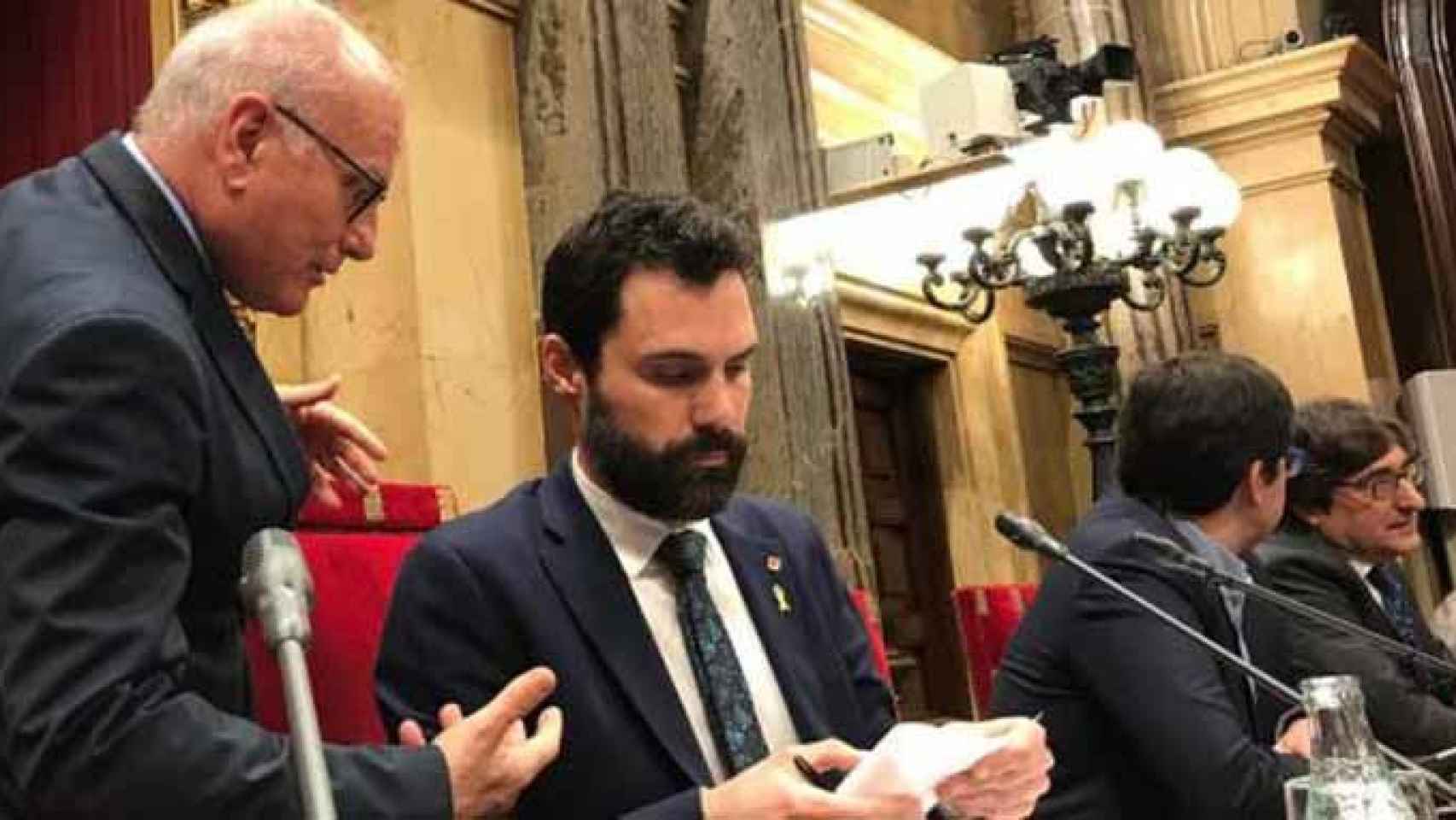 El presidente del Parlament Roger Torrent, que en la imagen conversa con el secretario de la Cámara, Xavier Muro, ha dado luz verde a una querella contra el juez Pablo Llarena / EUROPA PRESS