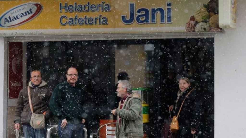 Vecinos resguardándose de la nieve en Utiel (Valencia) / EFE
