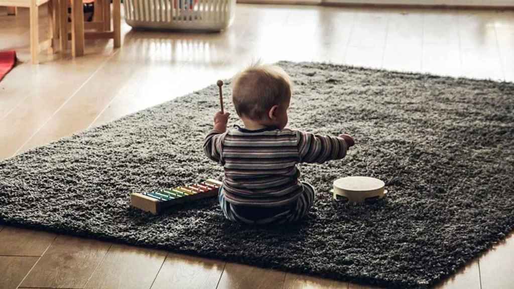 Un niño pequeño toca instrumentos musicales en casa