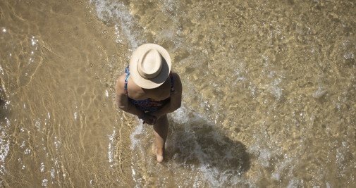 Una mujer paseando por la orilla de la playa de La Concha de San Sebastián / EFE - Javier Etxezarreta