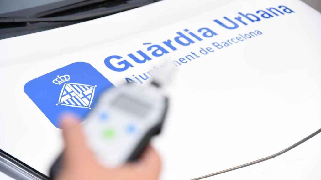 Alcoholímetro para medir la tasa de alcohol en aire aspirado junto al logo de la policía barcelonesa / GUARDIA URBANA BARCELONA