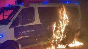 El furgón de la Guardia Urbana en llamas durante los disturbios del 27 de febrero en Barcelona / ELENA BURÉS