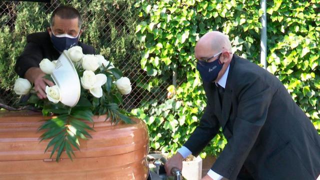 Dos trabajadores funerarios trasladando un féretro / EFE