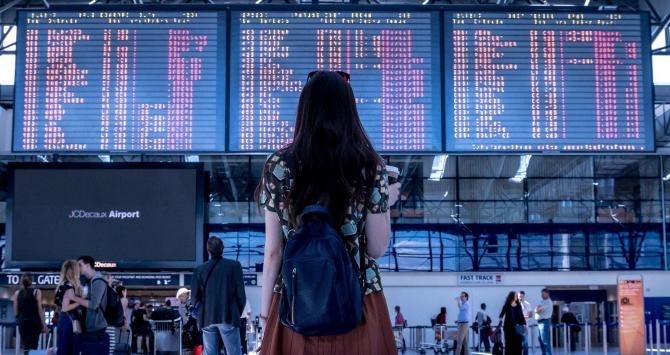 Una mujer contempla el panel de vuelos de un aeropuerto / CG