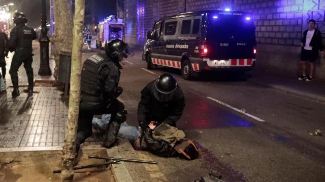 Dos agentes de los Mossos d'Esquadra detienen a una personas / EFE