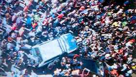 Una multitud de gente rodeando un coche de la Guardia Civil / CG