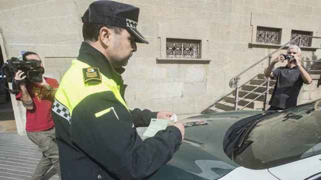 El jefe de la Policia Local de Olot, Ignasi López, multa a las furgonetas de la Guardia Civil mal estacionadas / EFE