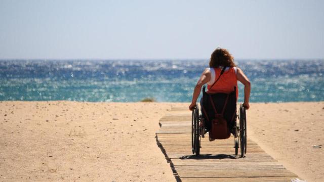 Una mujer en silla de ruedas visitando la playa en Cataluña / M.PEINADO - WIKIMEDIA COMMONS