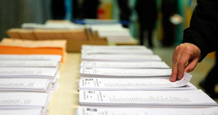 Un ciudadano eligiendo una papeleta para votar / EFE
