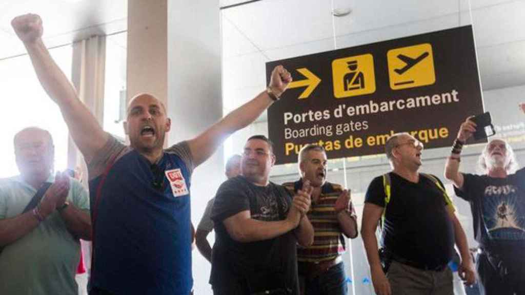 Los trabajadores de Eulen, con pegatinas de UGT y CCOO, protestan ante los arcos de seguridad de El Prat en una imagen de archivo / CG