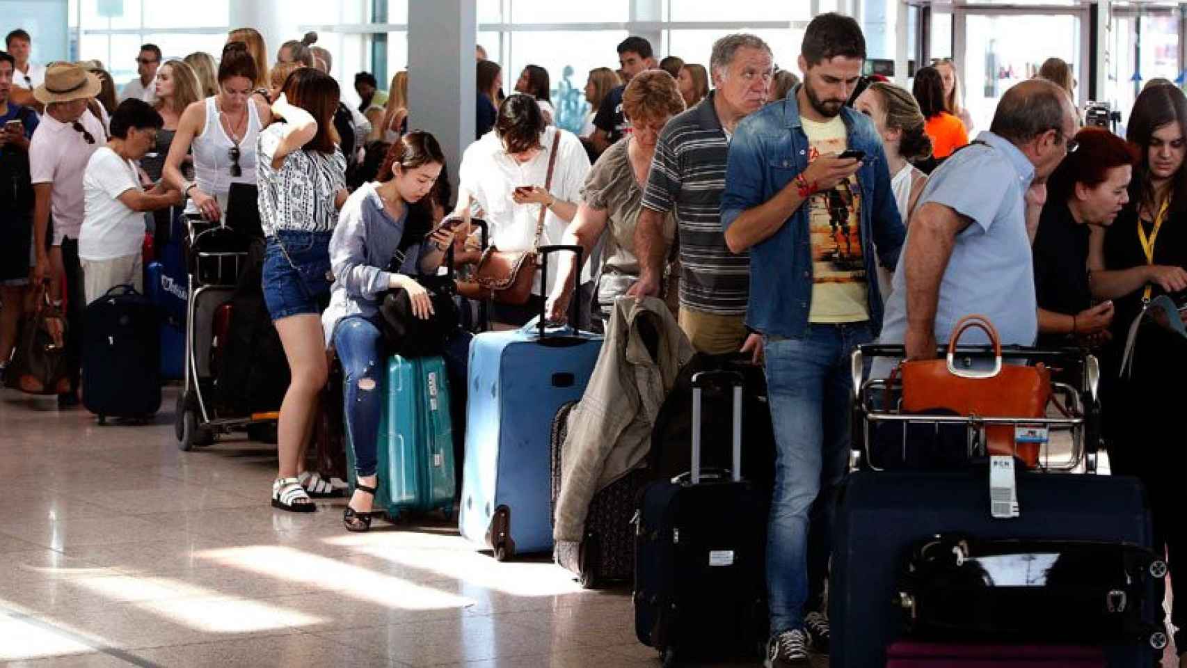 Un grupo de pasajeros hace cola en el aeropuerto.