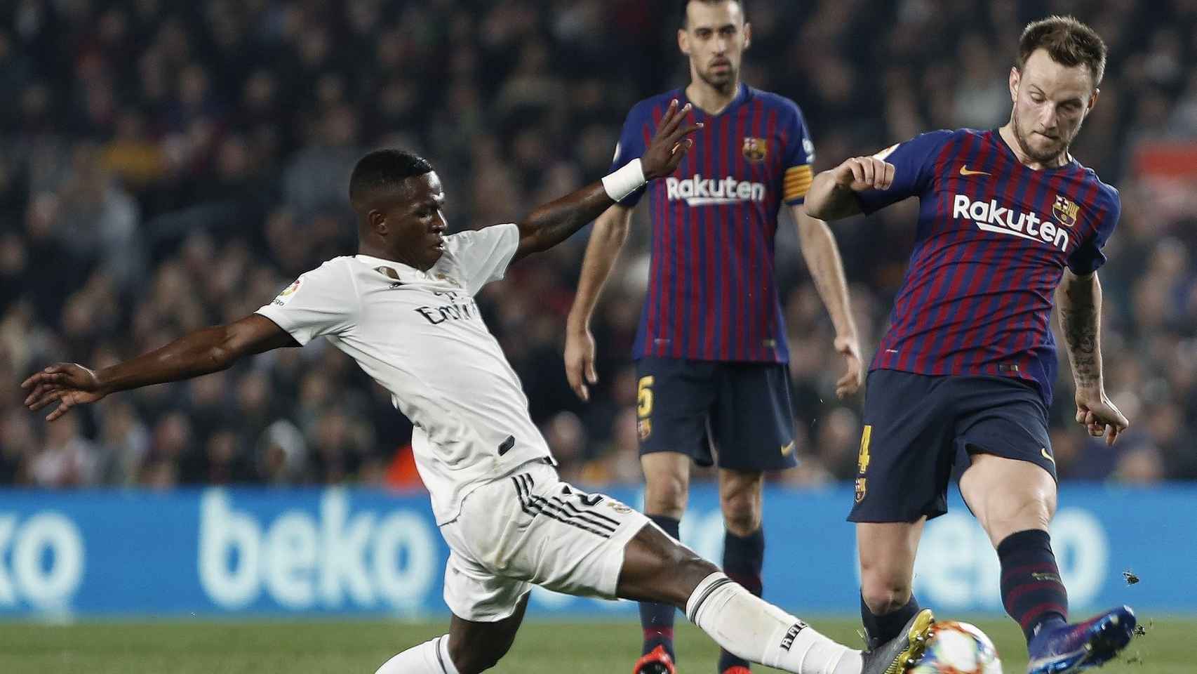 Ivan Rakitic intentando un pase delante la presión de Vinicius / EFE