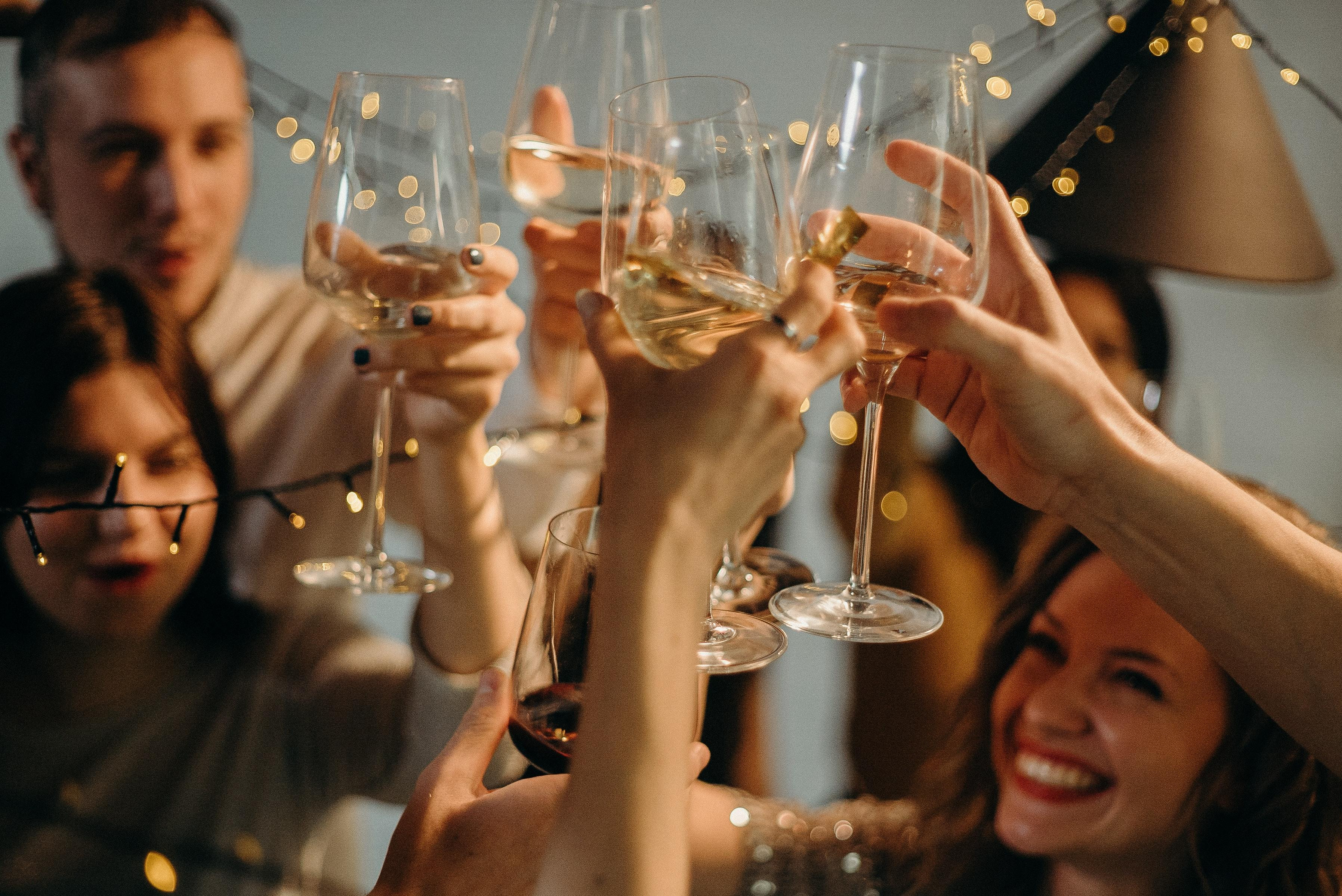 Un grupo de amigos brinda con vino en una cena de Navidad / PEXELS