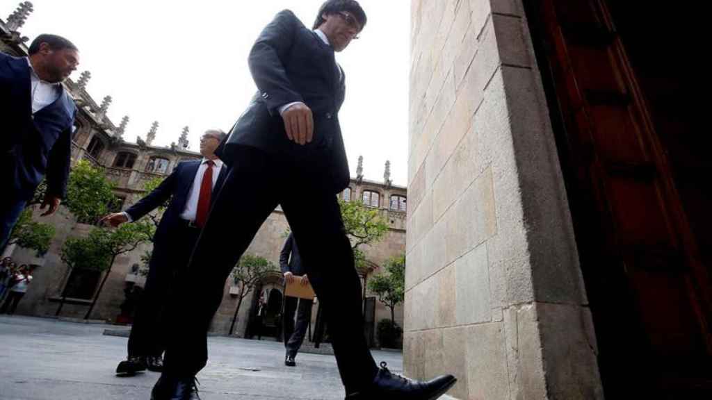 Carles Puigdemont (d) , junto al vicepresidente Oriol Junqueras (i), y el conseller de Presidencia, Jordi Turull (2i), a su llegada a la reunión extraordinaria del gobierno catalán / EFE