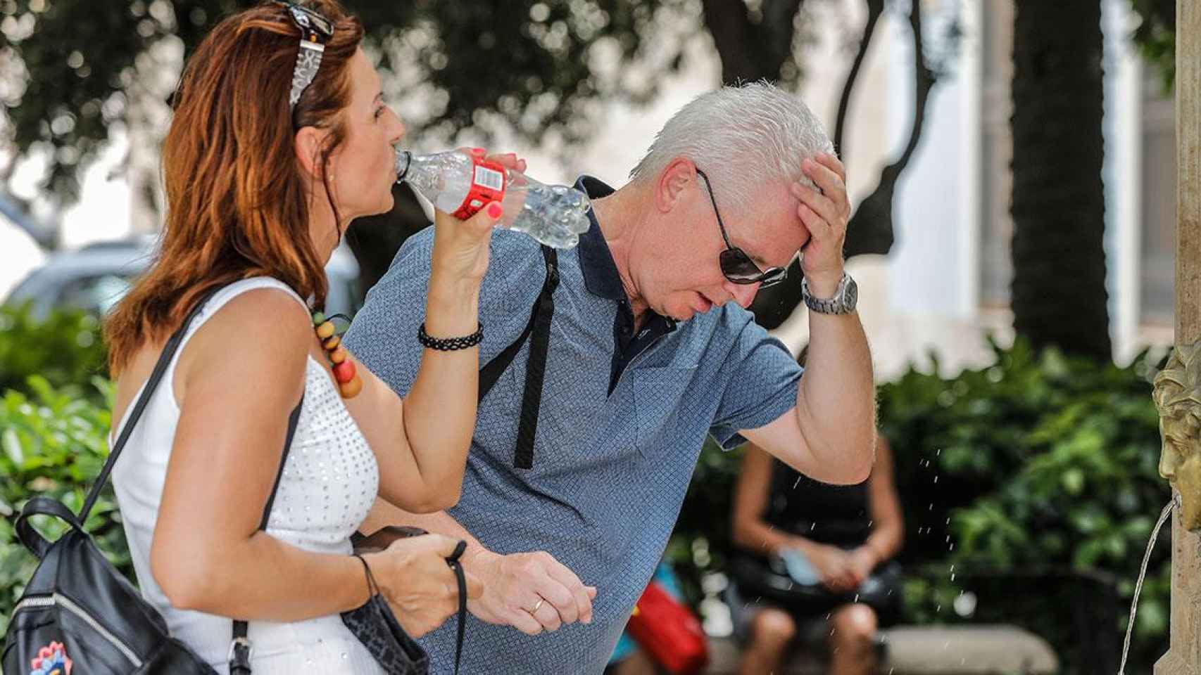 Dos personas se refrescan para combatir las altas temperaturas como las que se esperan Cataluña / EP