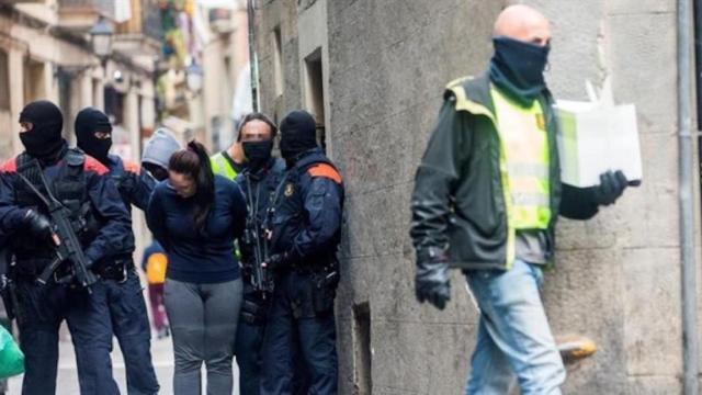 Agentes de los Mossos d'Esquadra custodiando a varios de los detenidos en la macrooperación contra los narcopisos de Barcelona /EFE