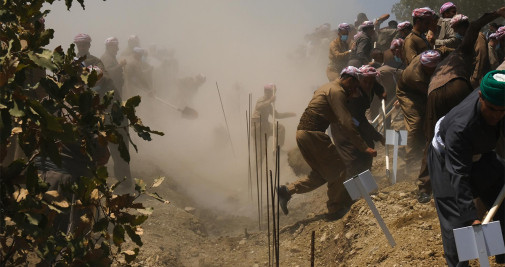 Ataúdes con los restos de 100 barzaníes son enterrados tras una ceremonia de reentierro en un monumento en Barzan, norte de Irak, este domingo - EFE/ Gailan Haji