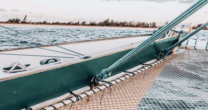 Imagen de la proa del 'Sail Beluga' en plena navegación por el litoral de Turks & Caicos durante la puesta de sol