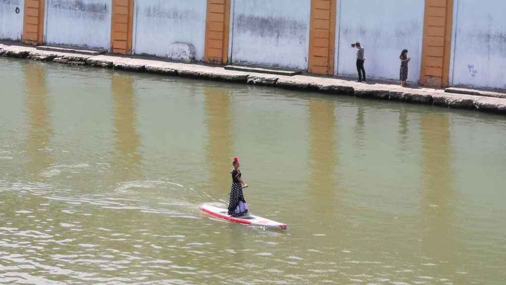 Una joven vestida de sevillana haciendo paddle surf por el Guadalquivir /REDES