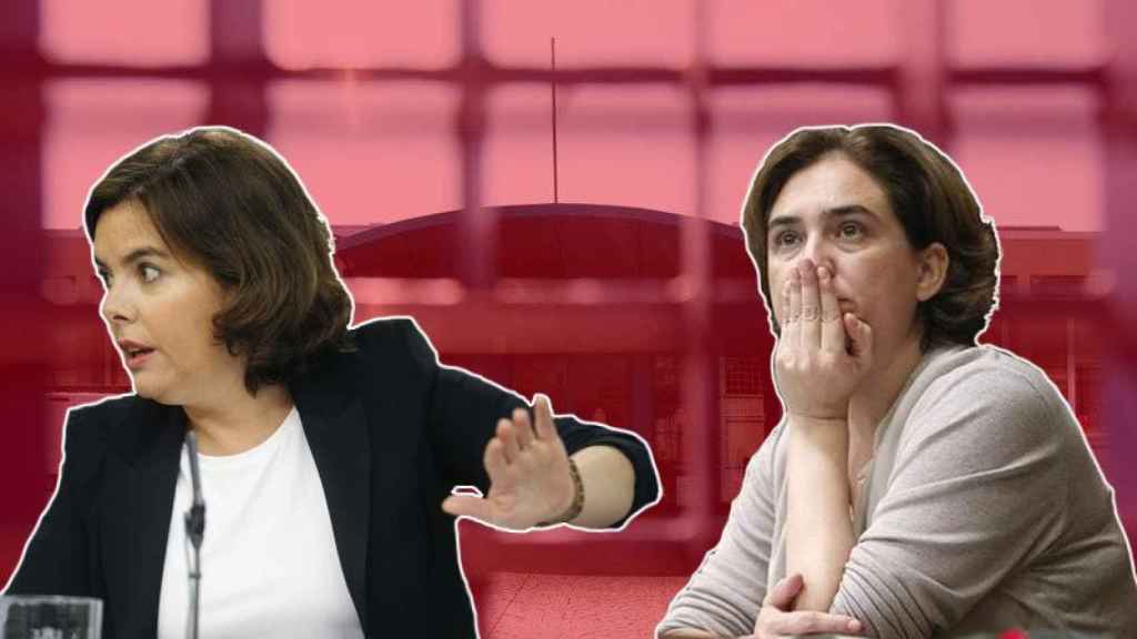 La vicepresidenta del Gobierno en funciones, Soraya Sáenz de Santamaría, durante la rueda de prensa posterior al Consejo de Ministros, y la alcaldesa de Barcelona, Ada Colau.