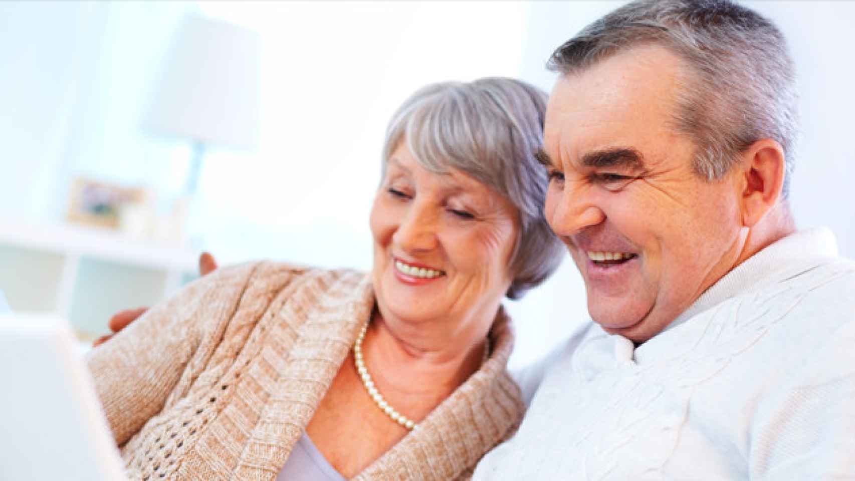 Pareja de jubilados consultando en un ordenador / CG