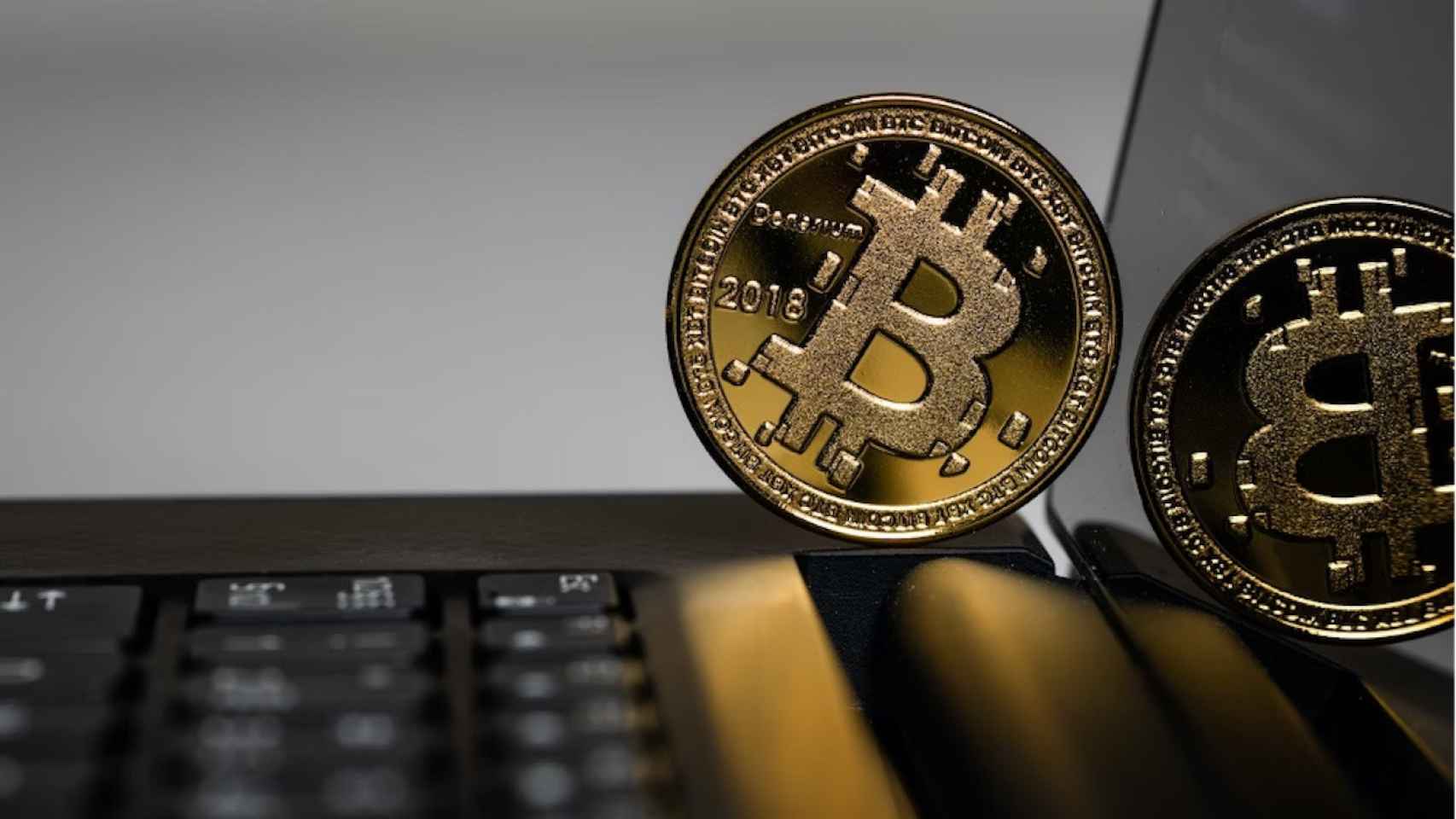 Bitcoin sobre portátil y reflejado en la pantalla