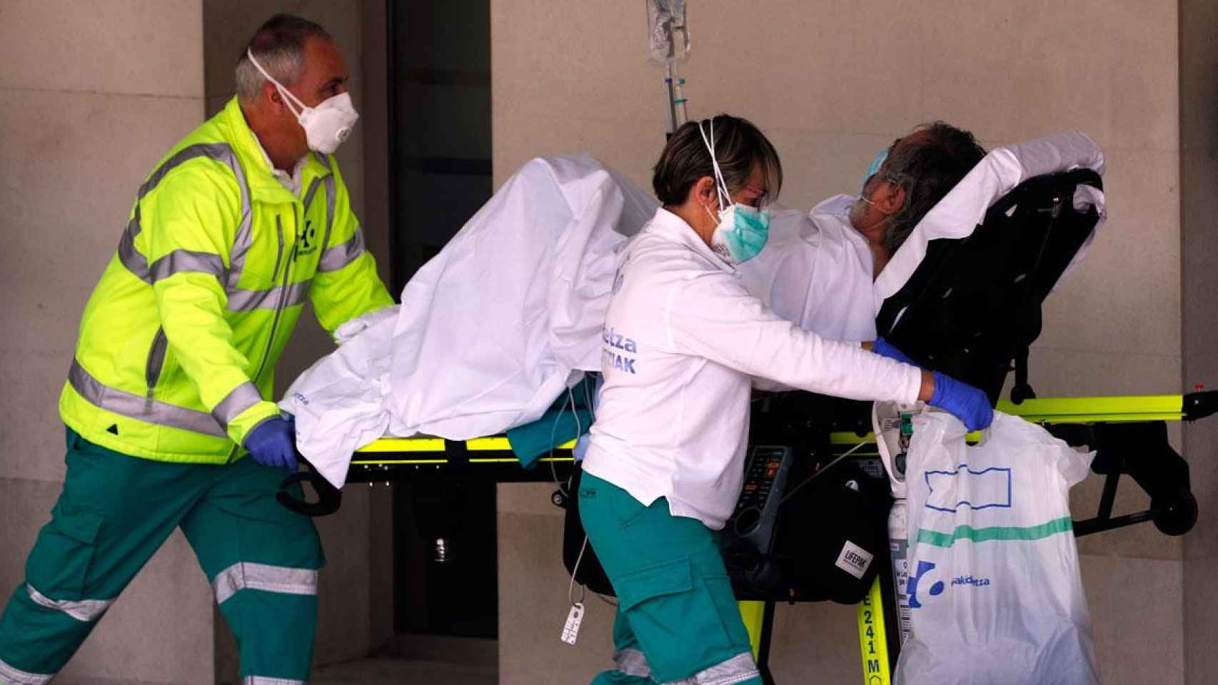 Dos sanitarios con mascarillas entrando a un paciente en un hospital / EFE