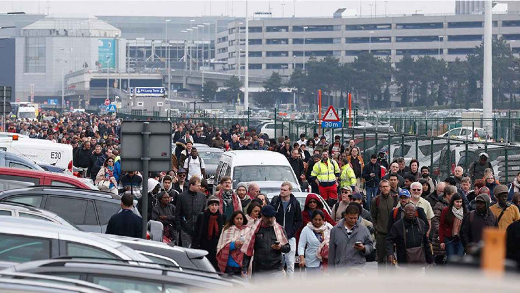 Centenares de pasajeros y empleados del aeropuerto de Zaventem abandonan las instalaciones tras los atentados.