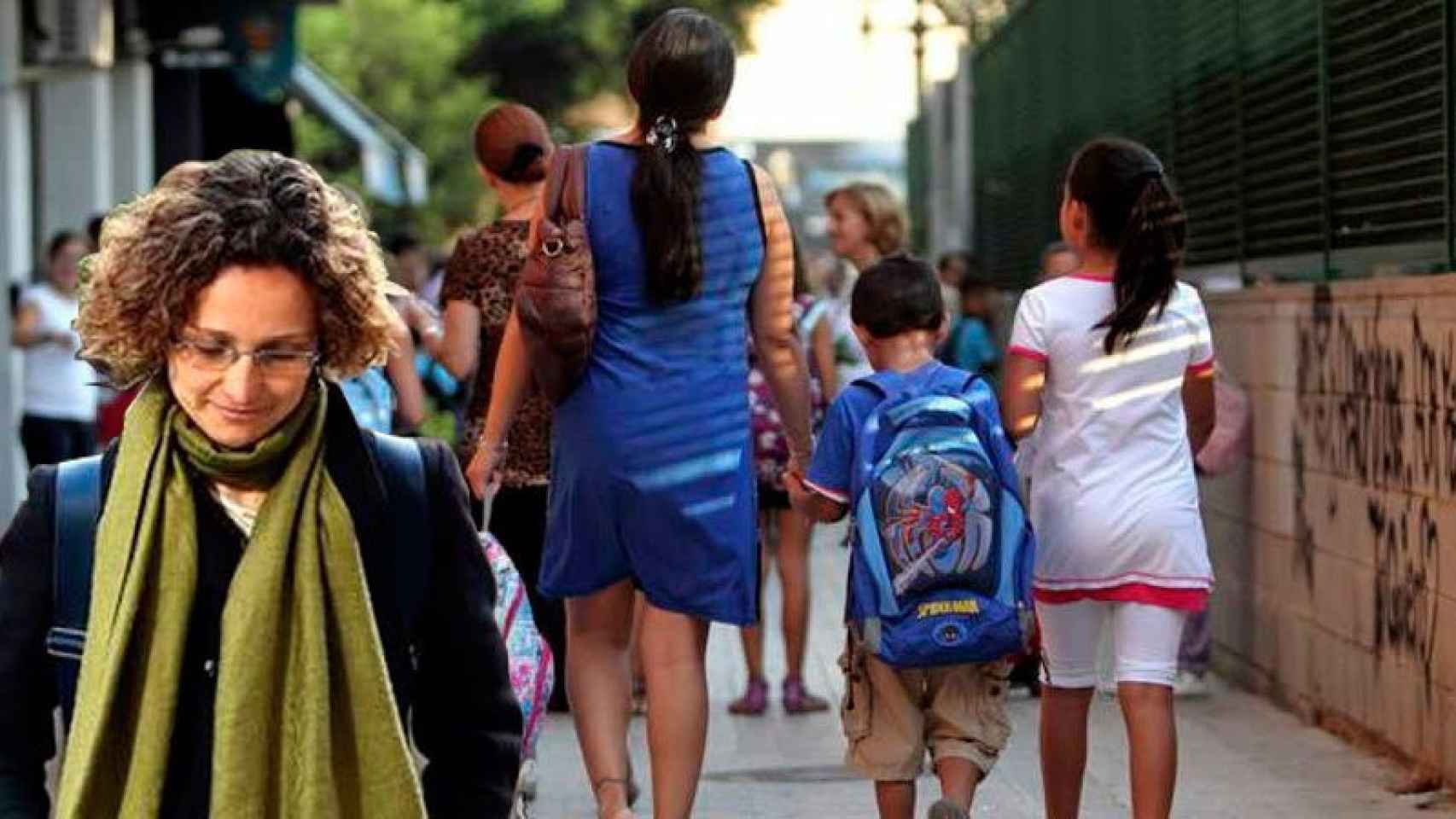 La consejera de Educación, Meritxell Ruiz, junto a una imagen de padres de alumnos de archivo.