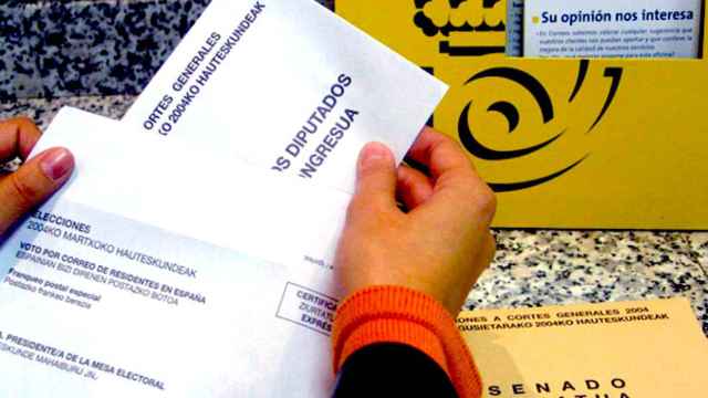 Imagen de archivo de la mano de una ciudadana que deposita su voto por correo en una oficina / EFE
