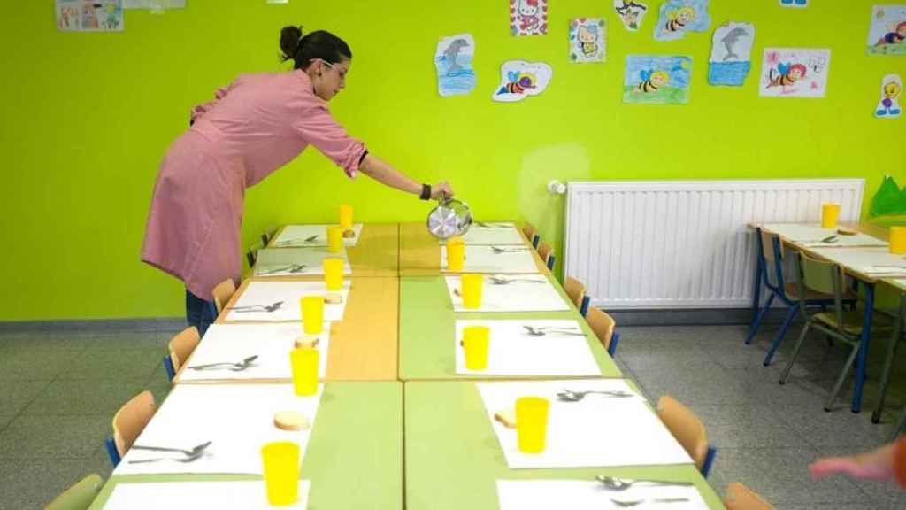 Monitora preparando el menú escolar, que se proporcionará para llevar a las familias en cuarentena / CG