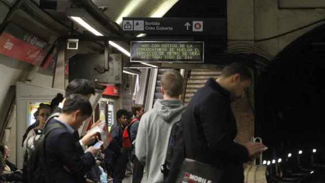 Imagen de archivo en la que varios usuarios del Metro de Barcelona observan la pantalla que anucia una convocatoria de huelga / EFE