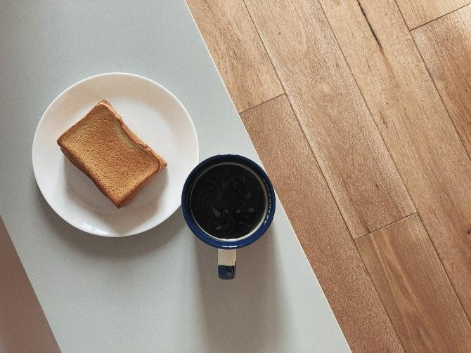 Café con pan tostado sobre el cual se puede frotar un ajo crudo / Yue Iris en UNSPLASH