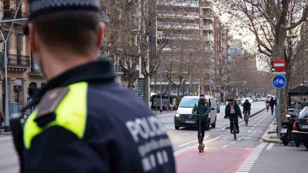 Un agente de la Guardia Urbana observa a un patinete eléctrico en circulación / AJUNTAMENT DE BARCELONA