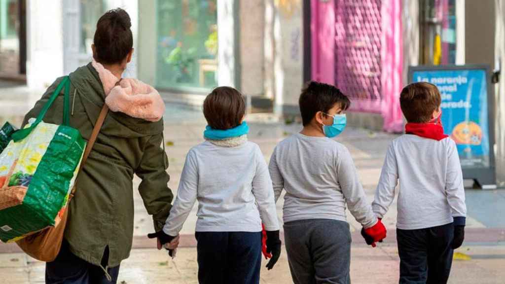 Tres niños acompañan a su madre a la compra durante el estado de alarma / EFE