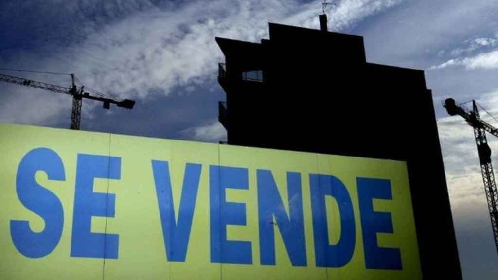 Un bloque de pisos en construcción con un cartel de 'Se vende' / EFE