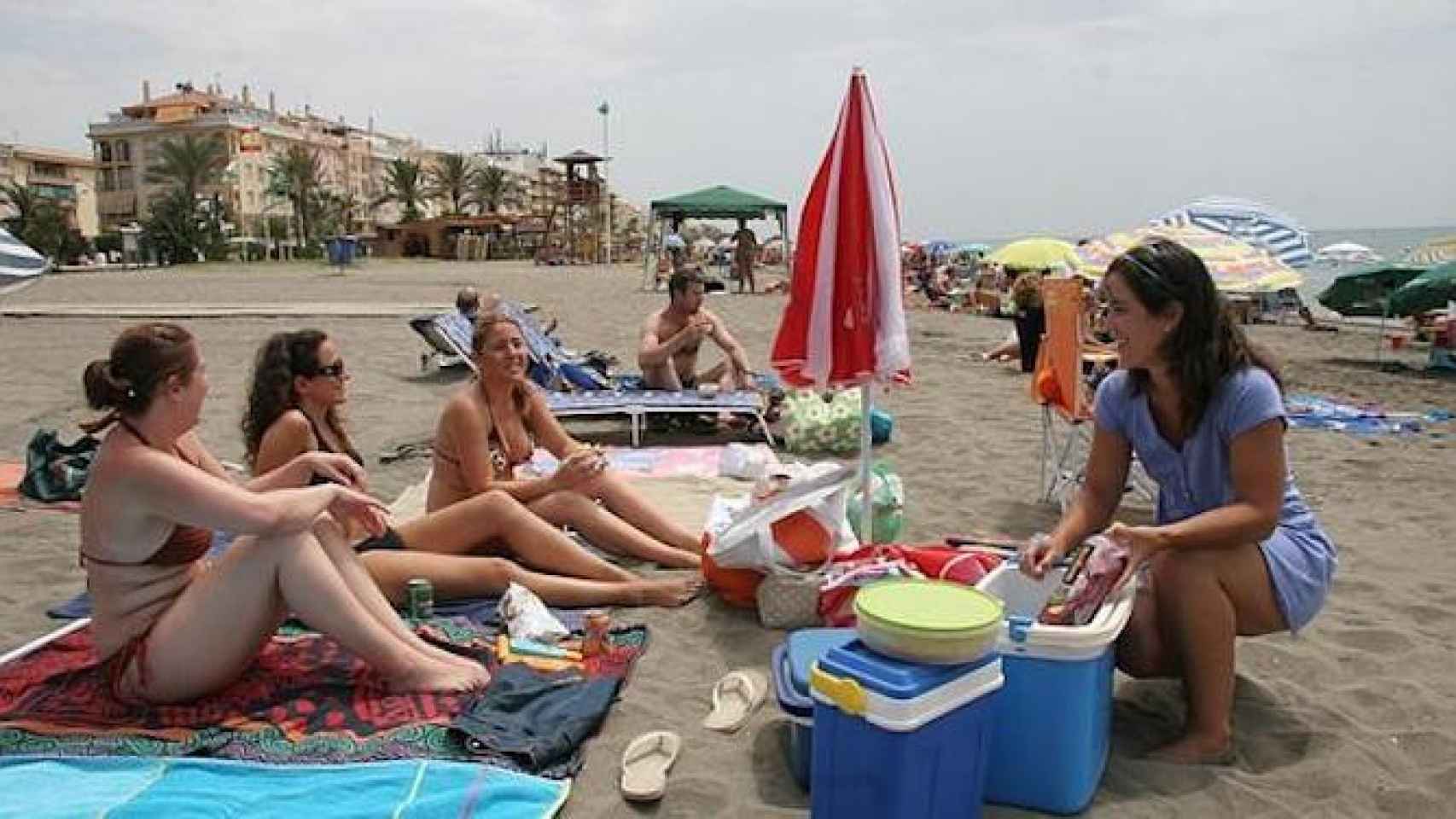 Un grupo de jóvenes se lleva la comida a la playa en verano