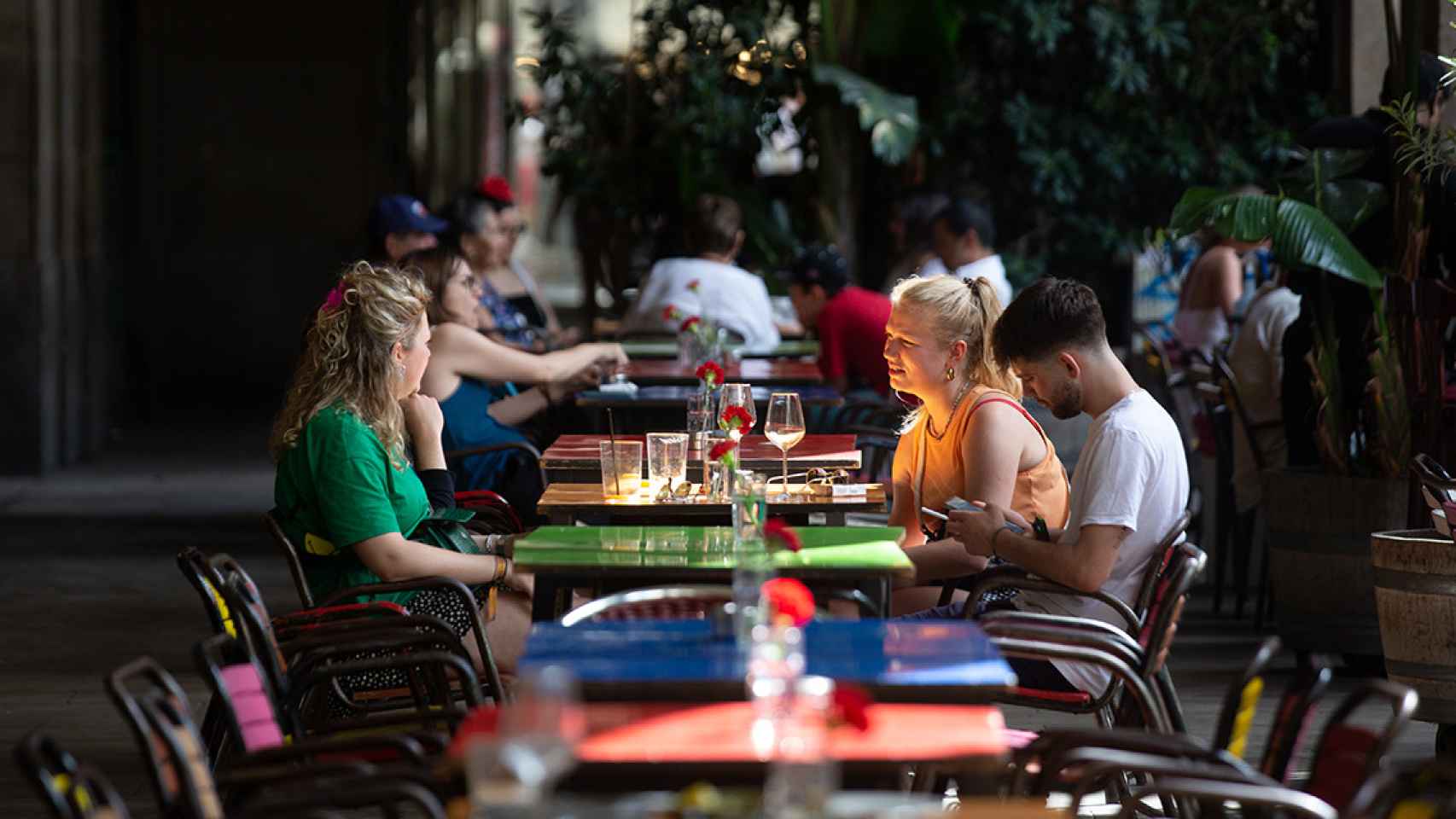 Varias personas sentadas en una mesa en la plaza Real de Barcelona este verano, en una imagen de archivo / DAVID ZORRAKINO - EUROPA PRESS