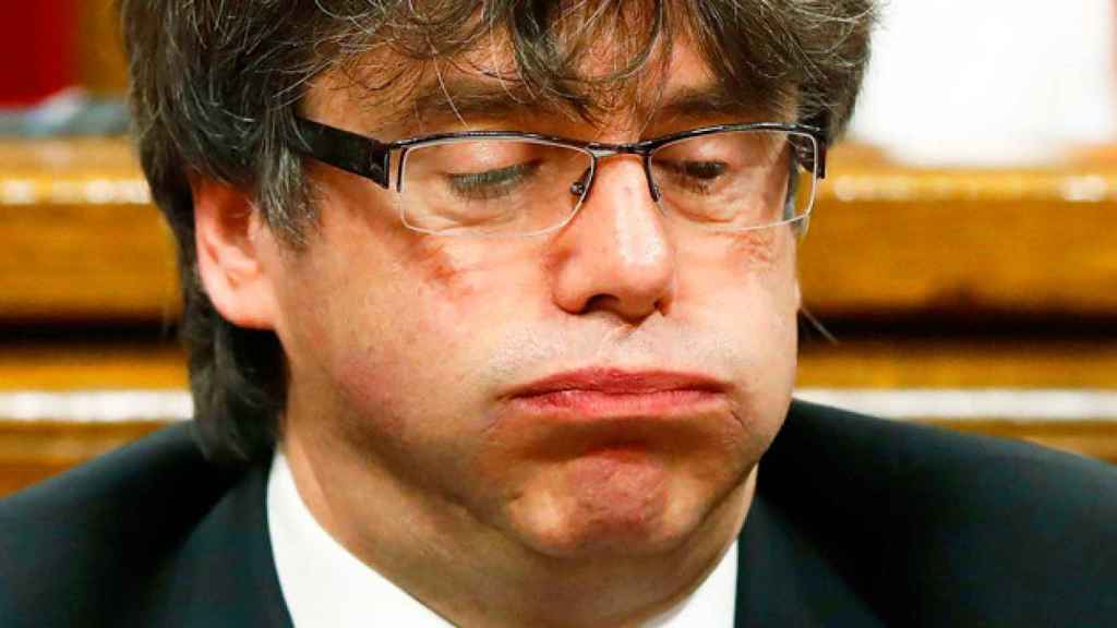 Carles Puigdemont con un gesto de agobio en el Parlament / EFE