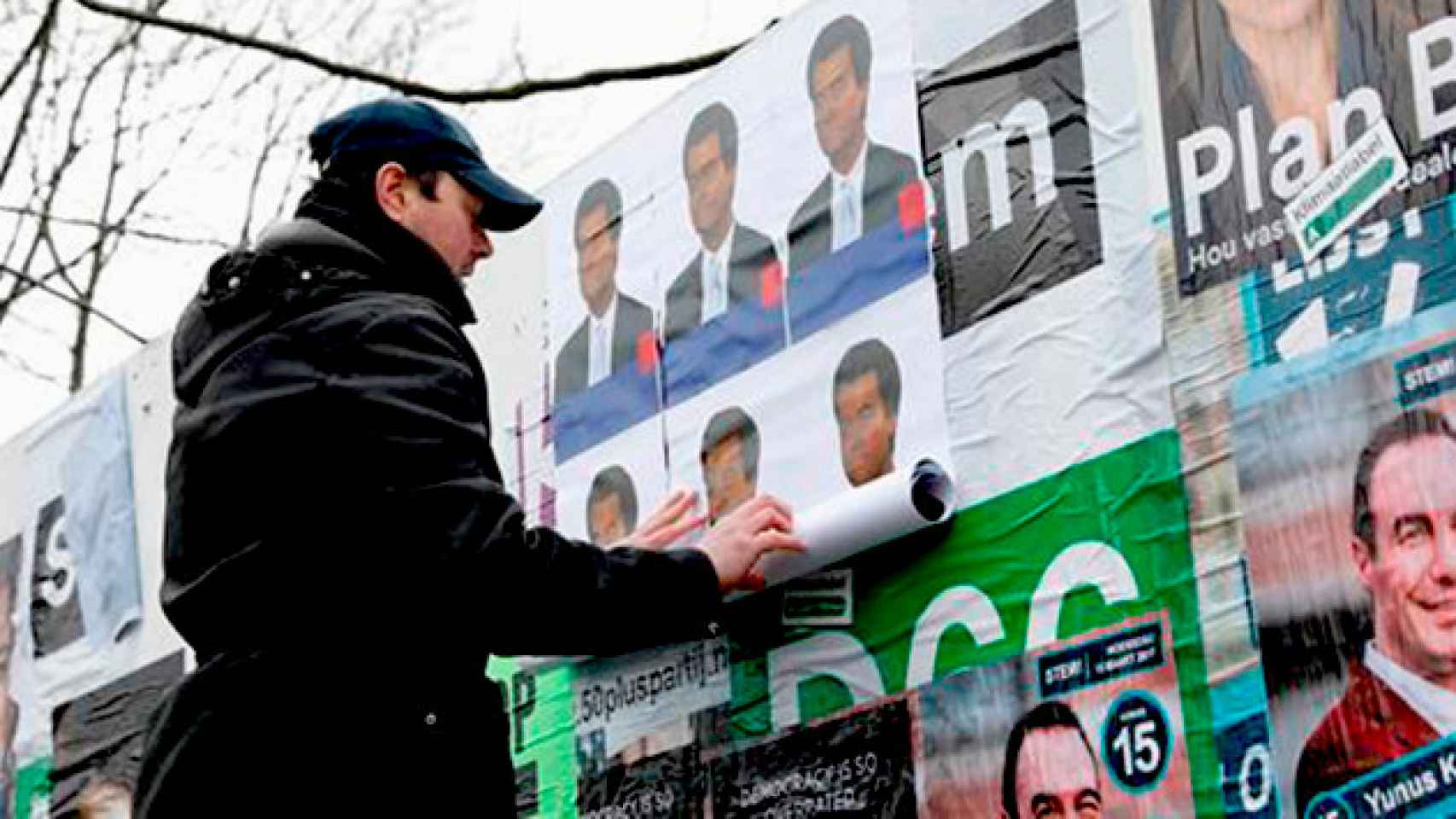 Un ciudadano holandés cuelga un cartel Geert Wilders en Ámsterdam (Holanda) / CG