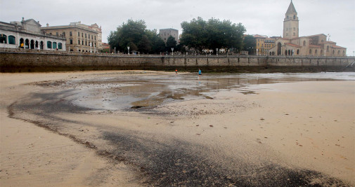 Manchas de carbón en la Playa de San Lorenzo, en Gijón, este viernes - EFE/Juan González