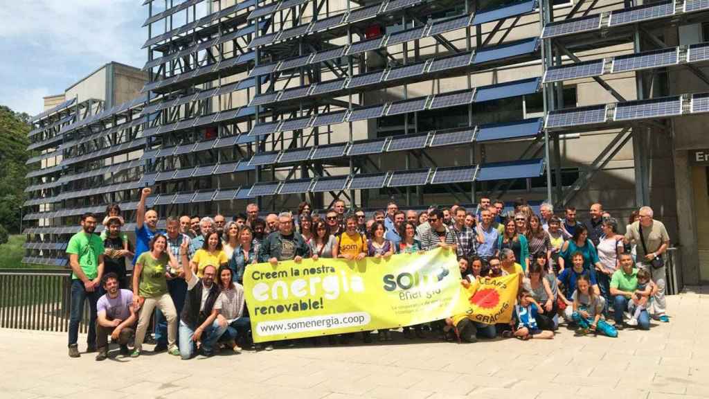 Socios de Som Energia, ante un edificio con placas solares / CG