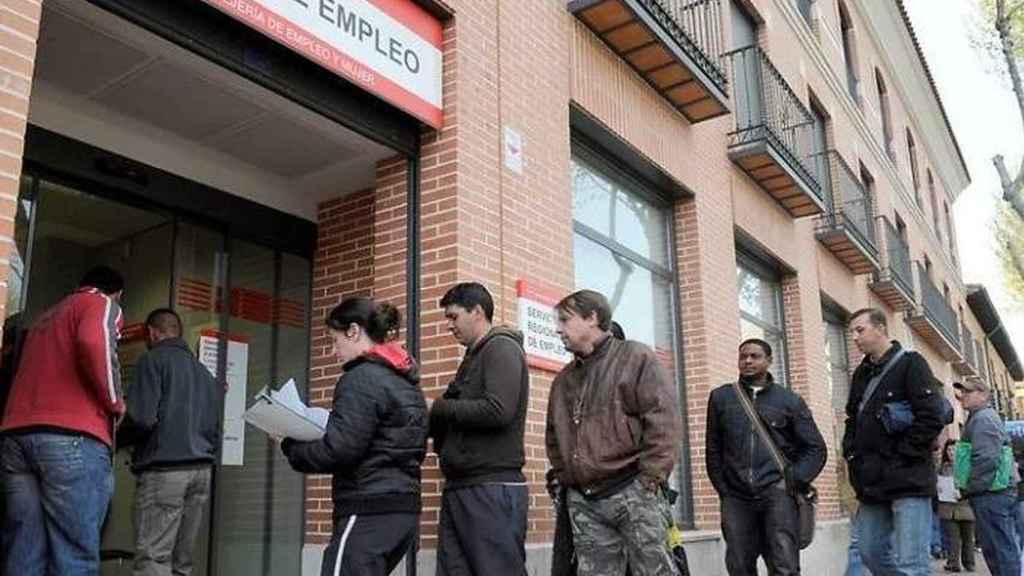 Un grupo de personas frente a una oficina de empleo por el aumento del paro