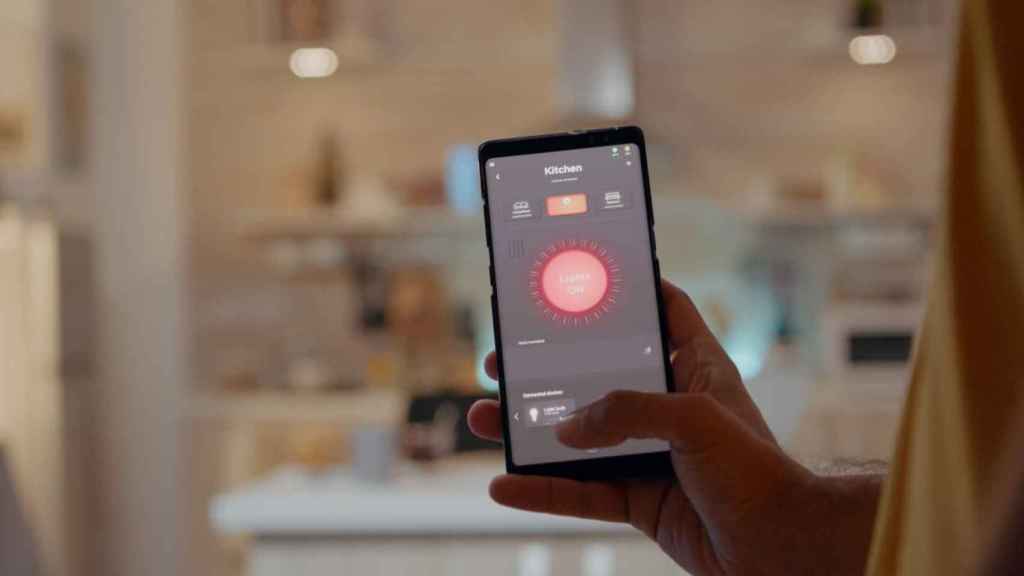 Una persona controla la iluminación de su cocina desde una aplicación para hogares inteligentes / FREEPIK