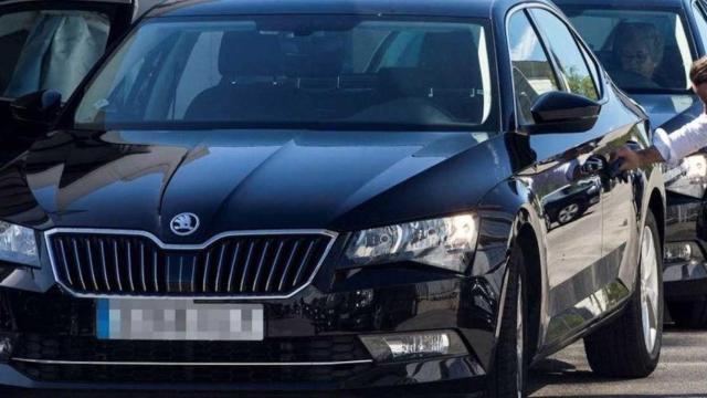 Un coche de VTC estacionado y su chófer en una calle de Barcelona / EFE