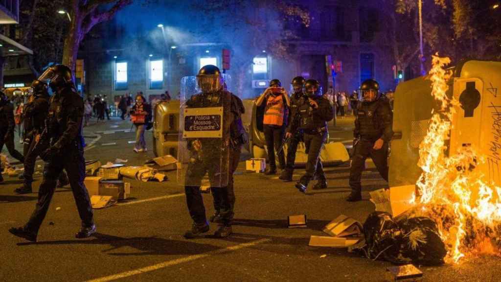 Varios Mossos delante de contenedores quemados en la plaza Urquinaona durante la manifestación por el cuarto aniversario del 1-O / Lorena Sopêna (EP)