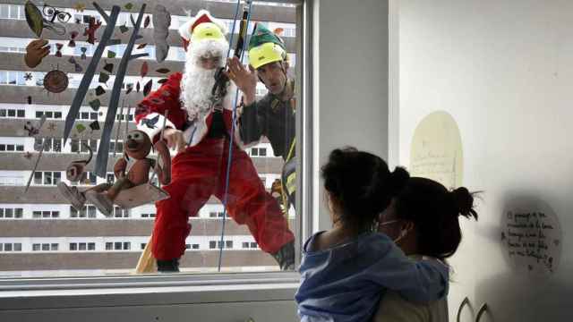 Papá Noel saluda a un niña ingresada para darle un regalo / David Oller - Europa Press