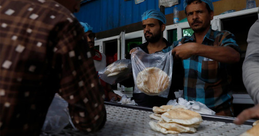 Los trabajadores recogen pan recién horneado en una panadería en medio de la inseguridad alimentaria, en Sana'a (Yemen), este miécoles - EFE/EPA/YAHYA ARHAB